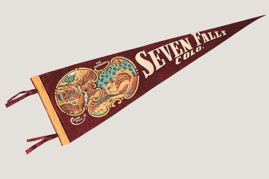 Pennant with 'Seven Falls, Colo.' text and map design on a white background