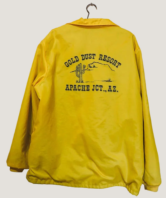 Yellow jacket with 'Gold Dust Resort Apache Jct., AZ' text on a wooden background